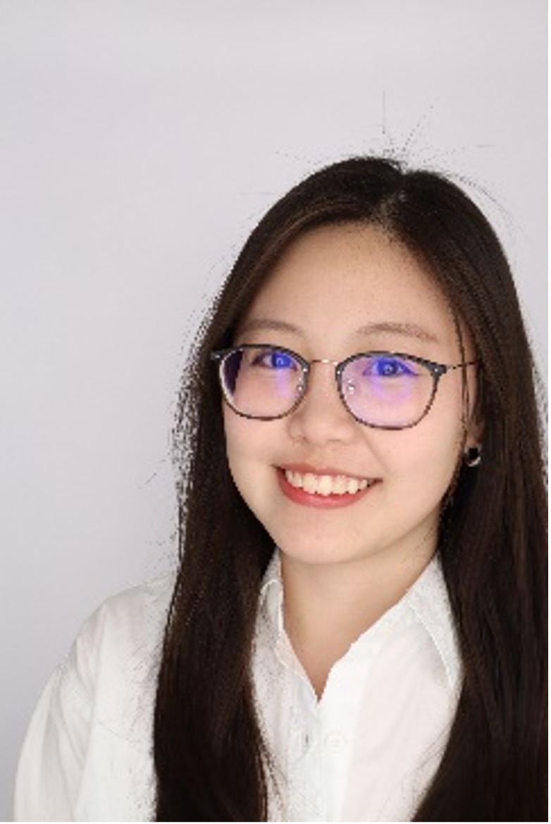 Headshot of Anh Nguyen, smiling, with long dark hair, glasses and a white shirt against a pale background.